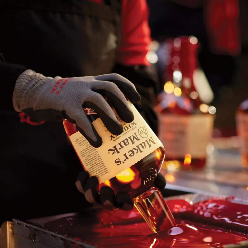 A bottle of Maker's Mark is dipped in their signature red wax